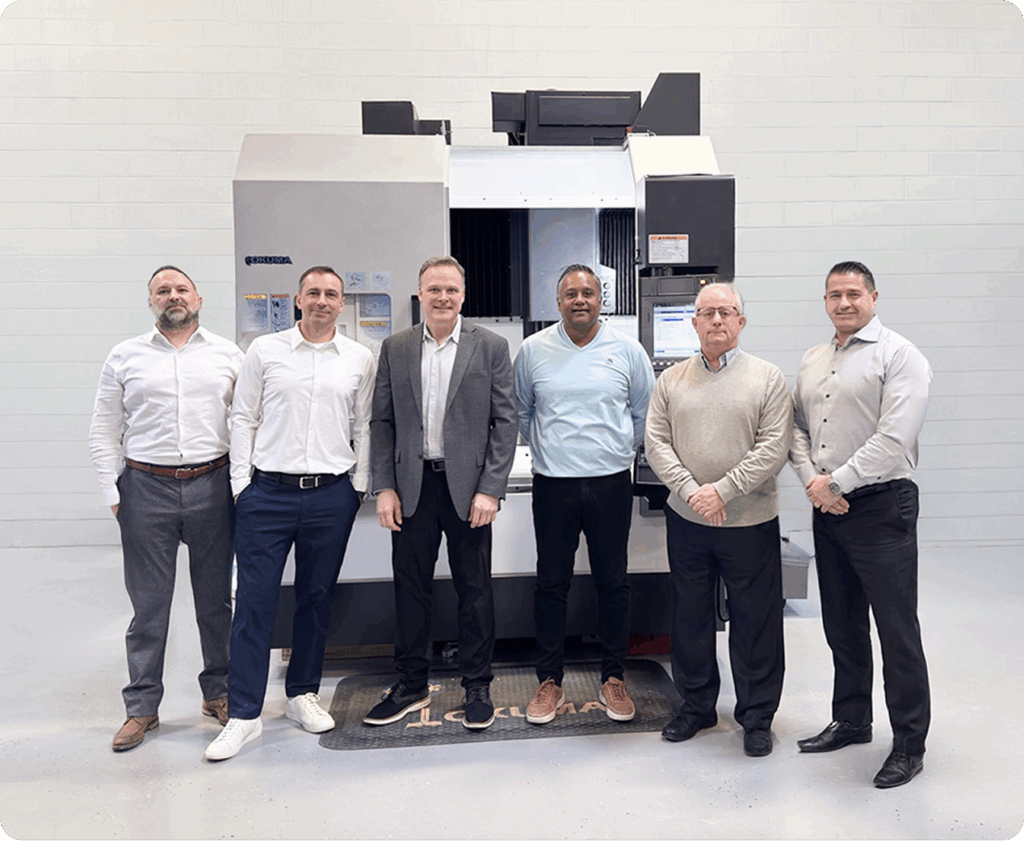 EMEC team standing in front of an Okuma CNC machine