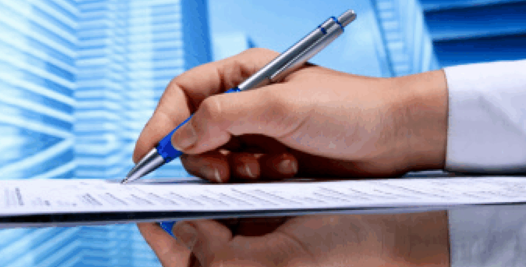 Hand writing on a document with a pen