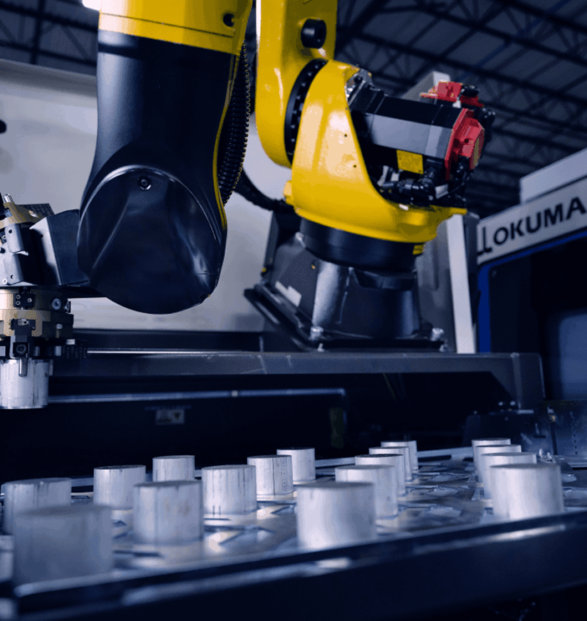 Industrial robotic arm operating an automated machine system